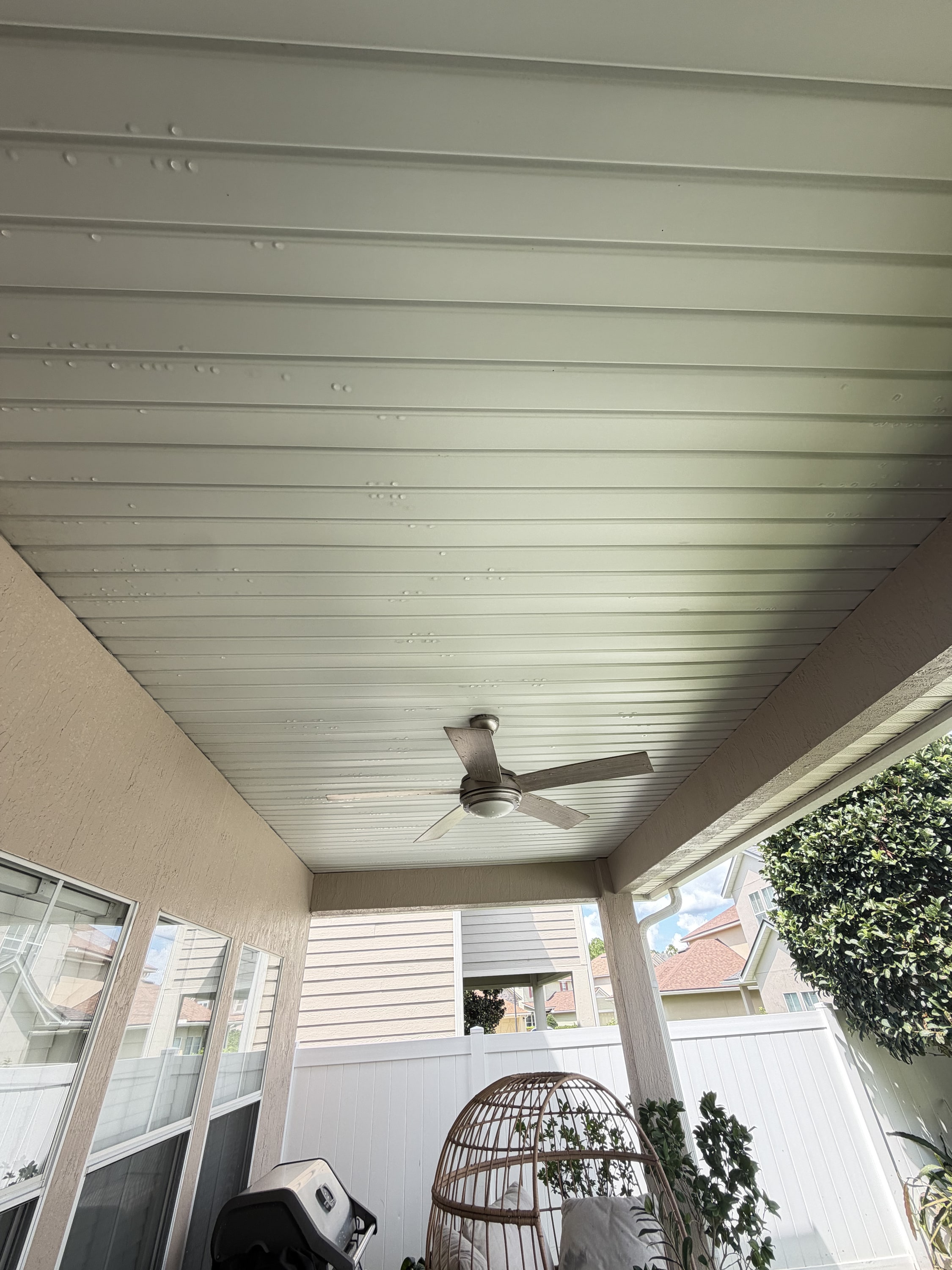 Cream soffit ceiling with recessed lights and ceiling fan on covered patio.