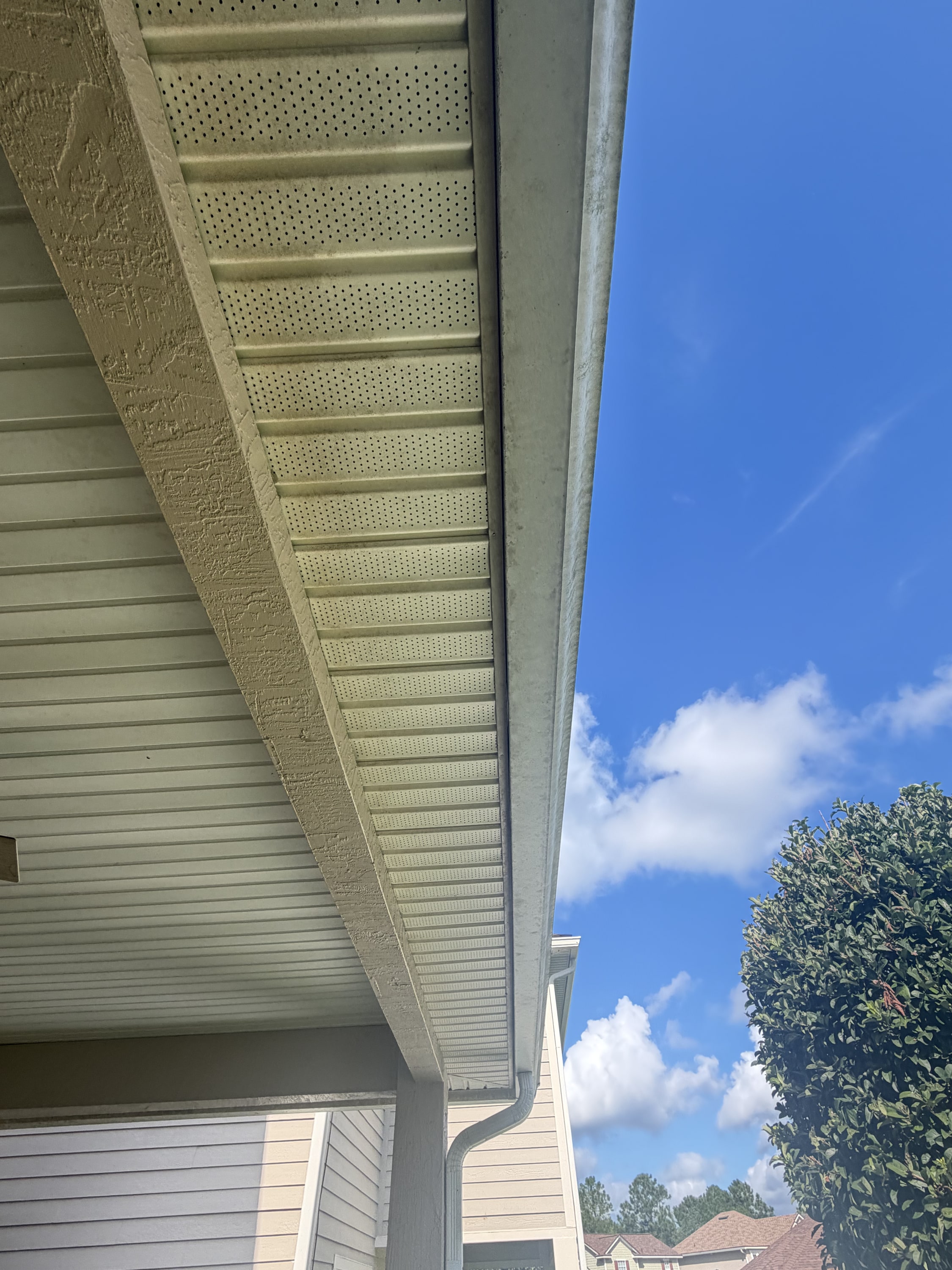 New soffit and fascia with perforated ventilation, installed under residential eave.