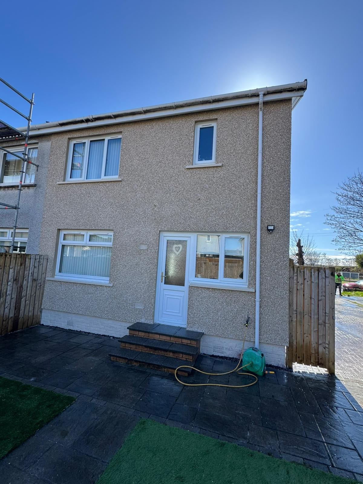 New guttering and downpipe installation on a rendered two-storey house